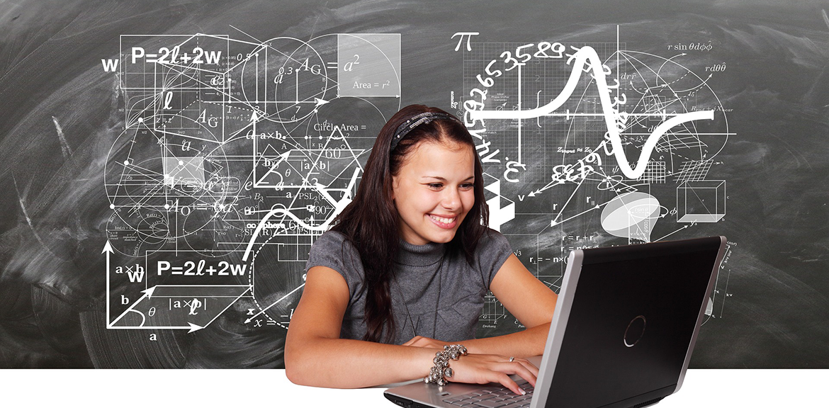 Young adult studying with laptop in front of blackboard