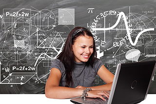Young adult studying with laptop in front of blackboard